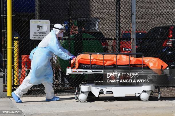 Medical staff move bodies from the Wyckoff Heights Medical Center to a refrigerated truck on April 2, 2020 in Brooklyn, New York. - The Federal...