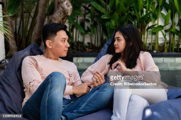 indonesisches paar plaudert am pool - asian couple arguing stock-fotos und bilder