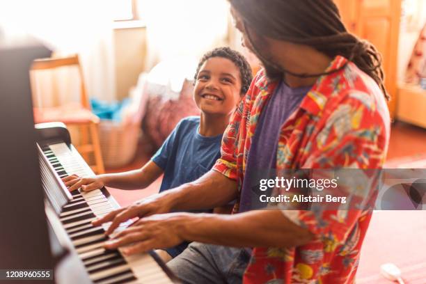 father and son playing piano together - talent team coaching imagens e fotografias de stock