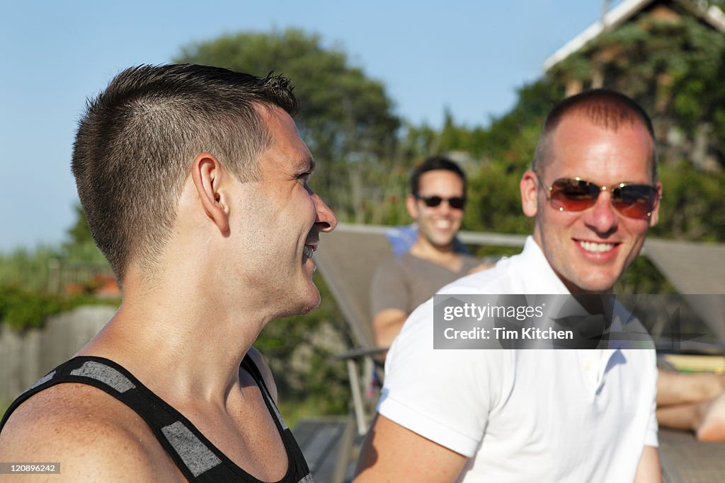 Friends relaxing on deck in summer, smiling