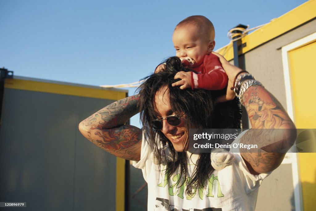 American drummer Tommy Lee of Motley Crue holding a baby backstage at... News Photo - Getty Images