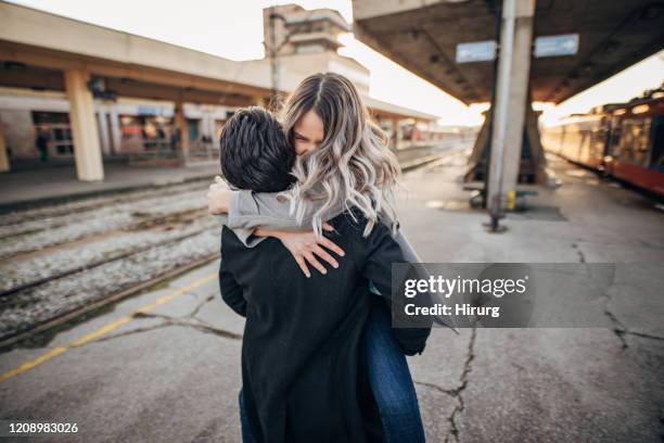 jeunes couples d’adolescent étreignant sur la gare - quai de gare photos et images de collection