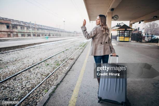 jeune adolescente quittant la gare - woman waving goodbye photos et images de collection