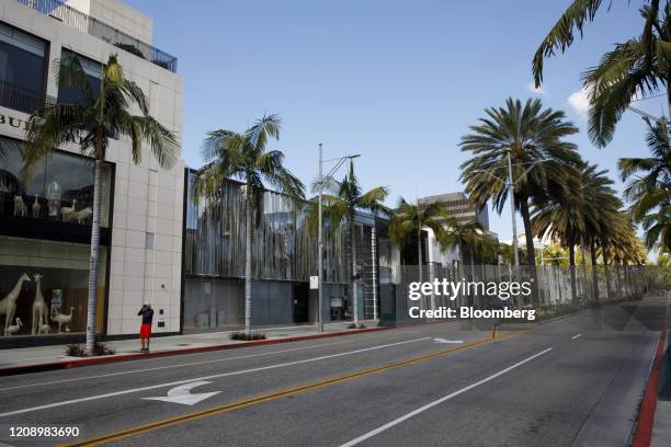 Person takes pictures of a nearly empty Rodeo Drive in Beverly Hills, California, U.S., on Thursday, April 2, 2020. The U.S. West Coast is offering...