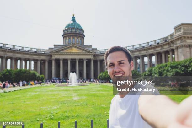 man visiting kazan cathedral and taking selfie as a memory - kazan cathedral st petersburg stock pictures, royalty-free photos & images