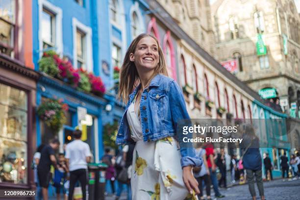 moderne vrouwelijke toerist die opgewekte dag besteedt die de straat van victoria in edinburgh bezoekt - edinburgh scotland stockfoto's en -beelden