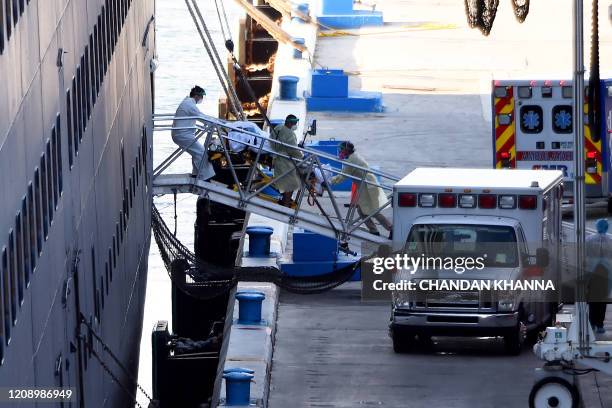 Medics pull out a patient on a stretcher from Holland America's cruise ship Zaandam as it is docked at Port Everglades in Fort Lauderdale, Florida on...