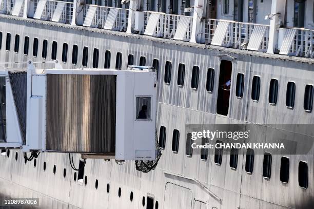 Staff of the port connects the air bridge with Holland America's cruise ship at Port Everglades in Fort Lauderdale, Florida on April 2, 2020. - The...