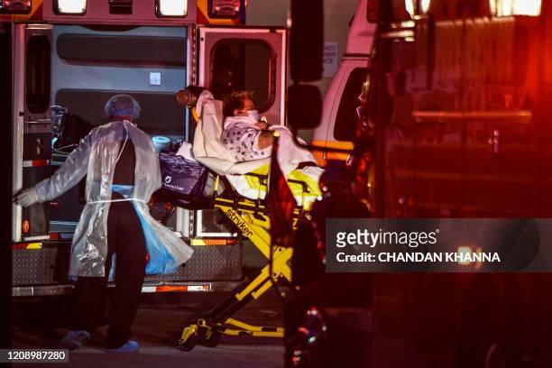 Medics transfer a ship passenger on a stretcher from an ambulance to Broward Health Medical Center in Fort Lauderdale, Florida on April 2, 2020. -...