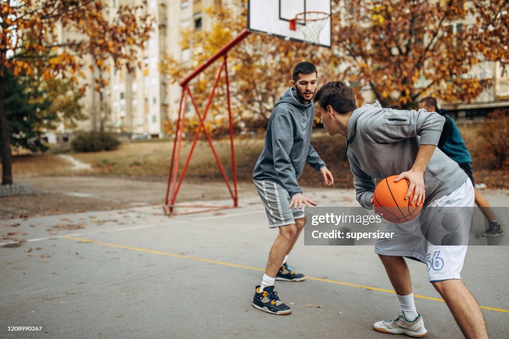 Two friends play basketball