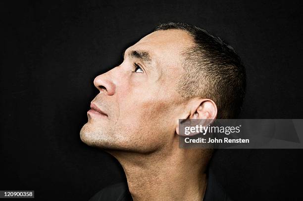 studio portrait on black - hispanic man profile hopeful stock-fotos und bilder