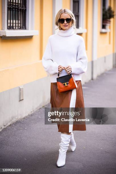 Victoria Magrath a.k.a. InTheFrow, wearing a white sweater, tan leather midi skirt, Tod's bag and white boots, is seen outside Tod's show, during...