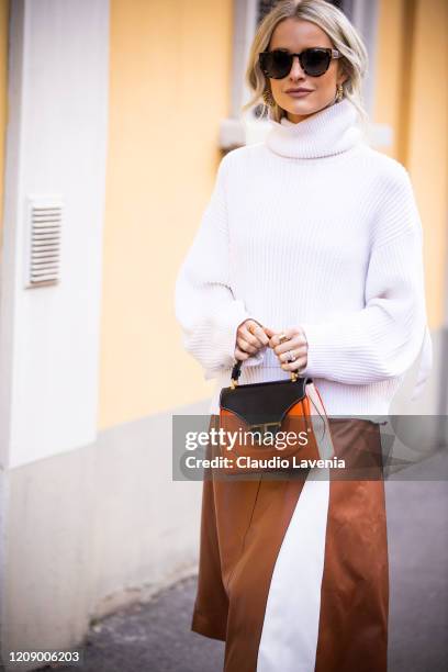 Victoria Magrath a.k.a. InTheFrow, wearing a white sweater, tan leather midi skirt and Tod's bag, is seen outside Tod's show, during Milan Fashion...