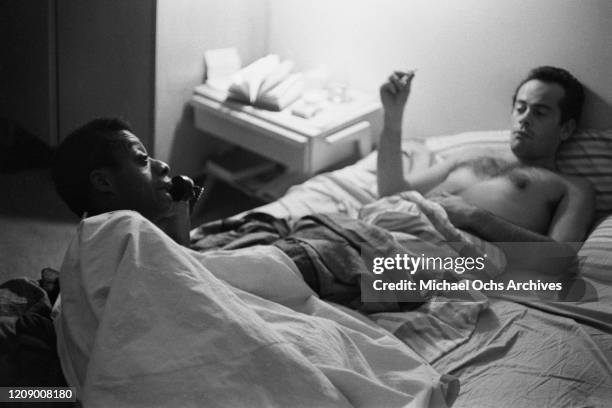 American novelist and activist James Baldwin in bed with his friend Lucien Happersberger, USA, October 1963.