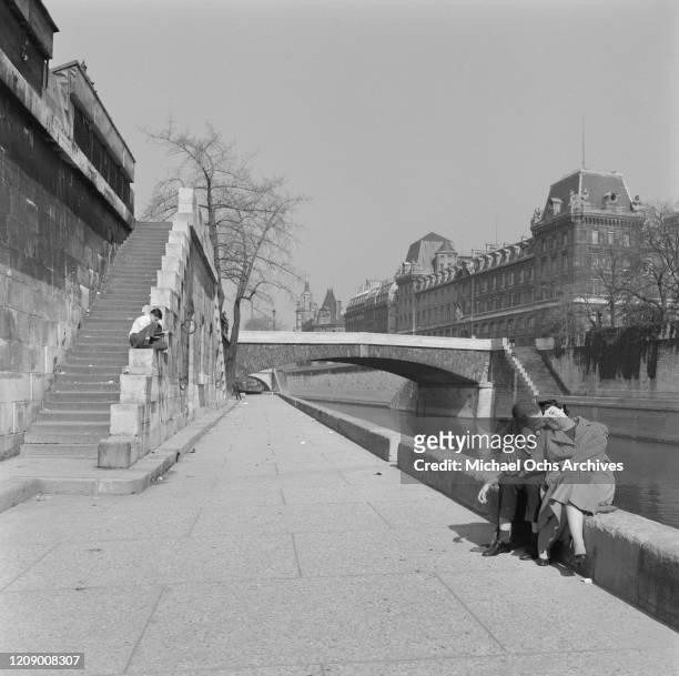 Couple on the banks of the River Seine in Paris, France, in the spring, April 1958.