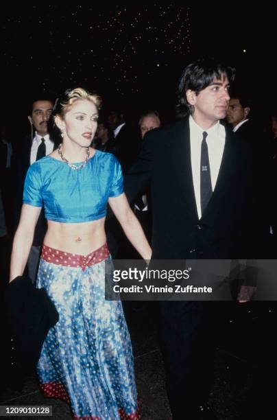 American singer Madonna with director Alek Keshishian and a navel piercing at the premiere of the film 'With Honors' at the Directors' Guild in...