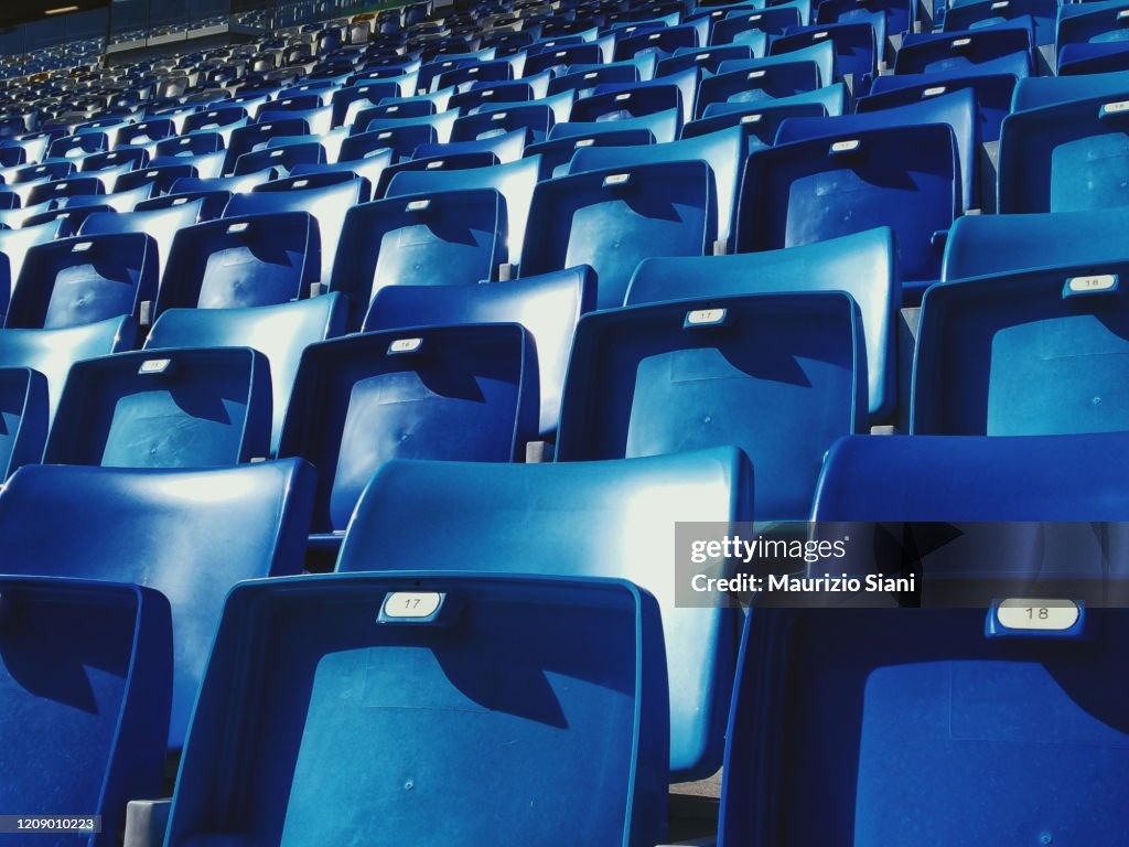 Empty blue arena seats with numbers in a stadium