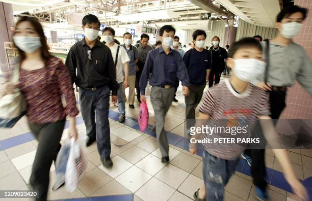 Photo prise le 22 avril 2003 à Hong-Kong de personnes portant des masques pour se protéger du Syndrome respiratoire aigu sévère . Le Sras a fait près...