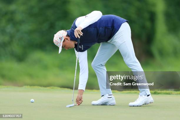 Rickie Fowler of the United States uses a divot tool during the first round of the Honda Classic at PGA National Resort and Spa Champion course on...