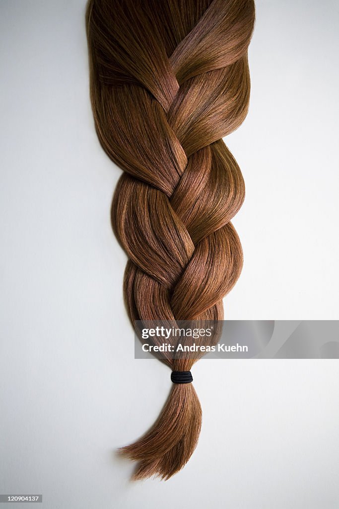 Still life of red haired braid on white background