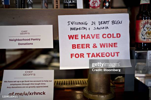 An alcohol takeout sign hangs on the bar at Chef Geoff's restaurant in Washington, D.C., U.S., on Thursday, March 26, 2020. As the wheels of...