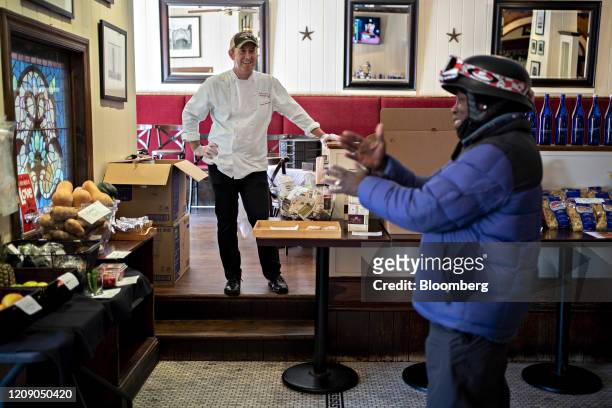 Restauranteur Geoff Tracy talks to a DoorDash Inc. Delivery person waiting for an order at Chef Geoff's restaurant in Washington, D.C., U.S., on...