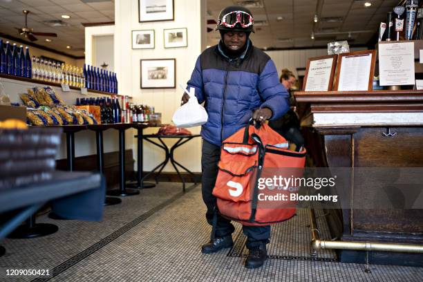 DoorDash Inc. Delivery person places an order into an insulated bag at Chef Geoff's restaurant in Washington, D.C., U.S., on Thursday, March 26,...