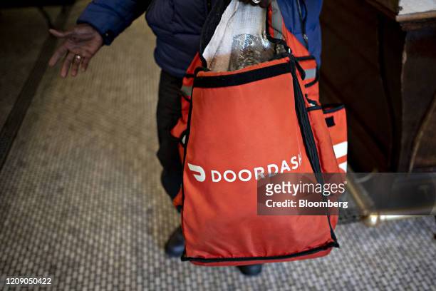 DoorDash Inc. Delivery person holds an insulated bag at Chef Geoff's restaurant in Washington, D.C., U.S., on Thursday, March 26, 2020. As the wheels...
