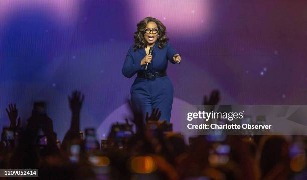 Oprah Winfrey points to the crowd as she talks during her tour stop at the Spectrum Center in Charlotte, N.C., on January 18, 2020.