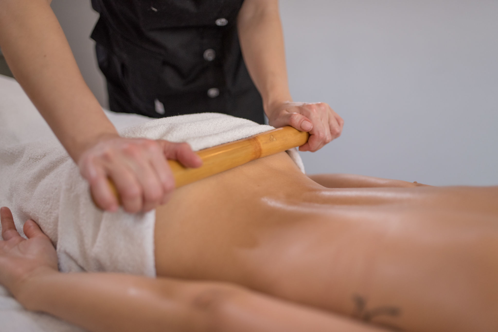 Woman is getting massage with bamboo stick in spa Woman is getting massage with bamboo stick in spa
