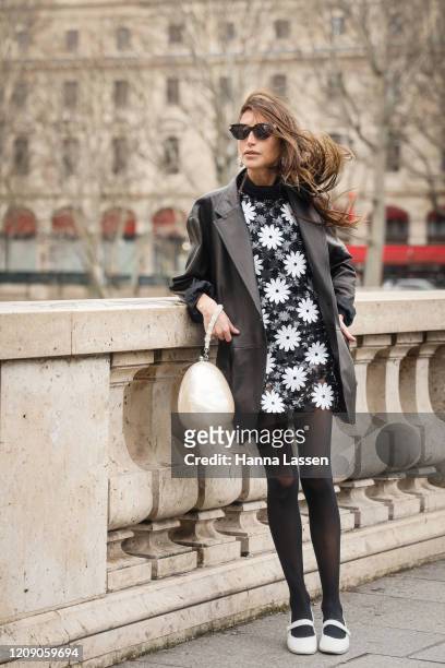 Chloe Harrouche wearing Paco Rabbane black leather jacket, daisy dress and white clutch outside the Paco Rabanne show during the Paris Fashion Week...