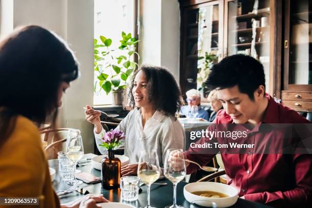 group of friends eating lunch together in restaurant - asian woman black shirt stock pictures, royalty-free photos & images