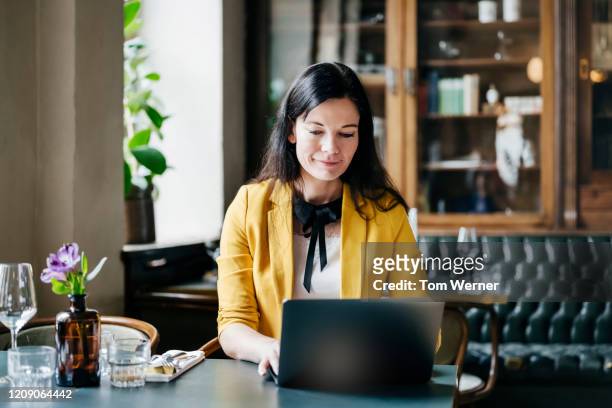 Restaurant Customer Sitting At Table Working On Laptop