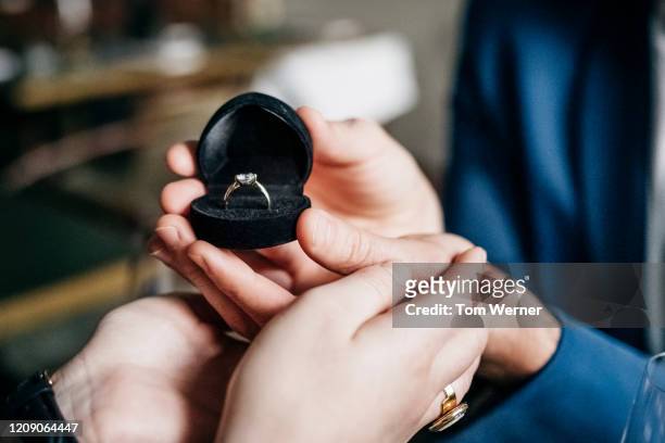close up of man presenting engagement ring to partner - fine jewelry stock pictures, royalty-free photos & images