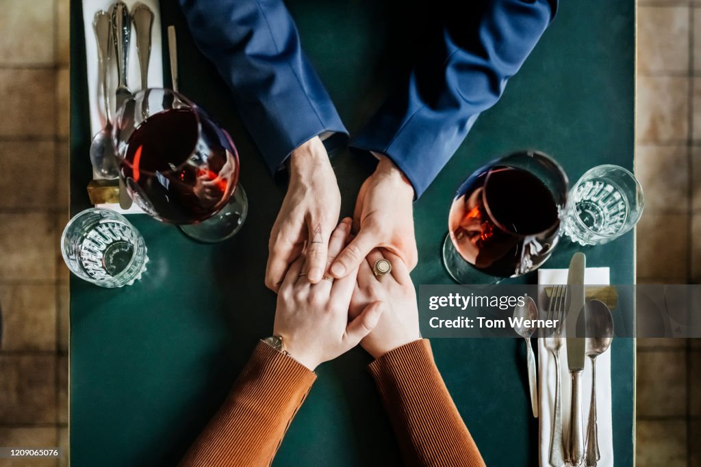 Aerial View Of Couple Holding Hands At Restaurant Table