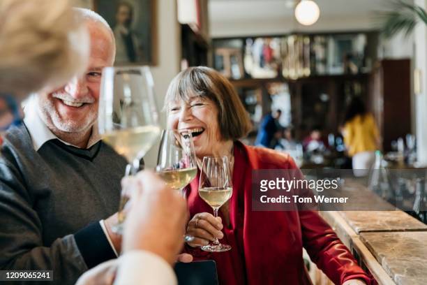 group of mature friends having fun at restaurant bar - retirement celebration stock pictures, royalty-free photos & images