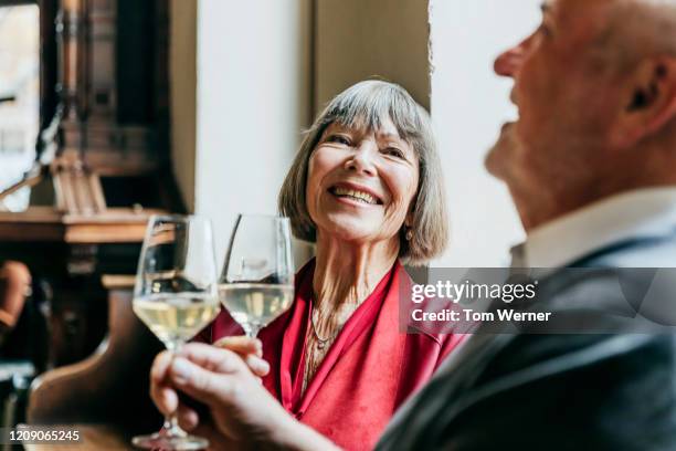 mature couple drinking wine at restaurant together - couple fine dining stock-fotos und bilder