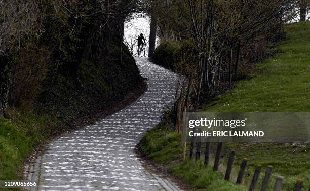 Person rides a bike on April 3 on the Koppenberg climb in Oudenaarde, usually a part of the track of "Tour of Flanders" cycling race. - The 104th...
