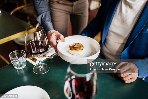 waiter serving customer starter dish in restaurant - fine dining restaurant table stock pictures, royalty-free photos & images