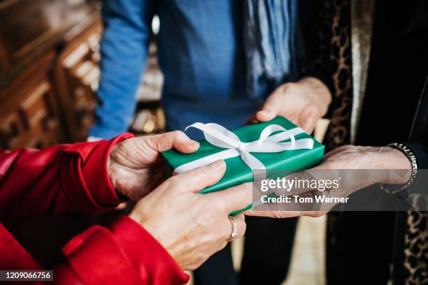 woman presenting friend with birthday gift in restaurant - grant bildbanksfoton och bilder