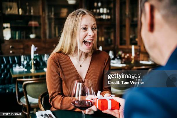 woman excited to receive gift in restaurant - surprise gift stockfoto's en -beelden