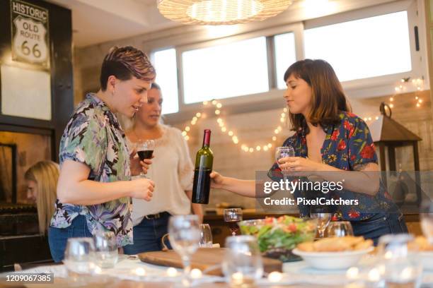 couple getting some wine refills at the barbecue celebration - empanadas argentina stock pictures, royalty-free photos & images