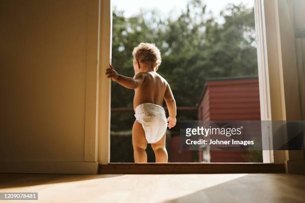 toddler standing in open door - kids in diapers - fotografias e filmes do acervo
