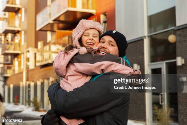 father and daughter hugging - abrigarse fotografías e imágenes de stock