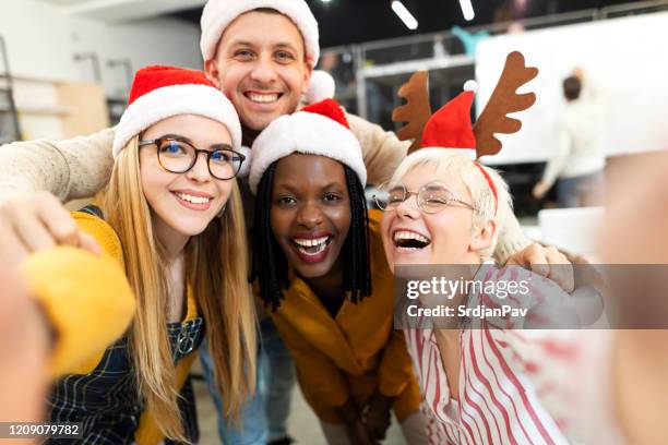 christmas celebration at the office - santa hat stock pictures, royalty-free photos & images