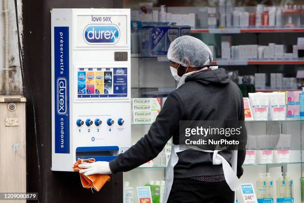 Man cleans a Condom box on March April 3, 2020 in Paris, during the lockdown in France to stop the spread of the novel coronavirus COVID-19.