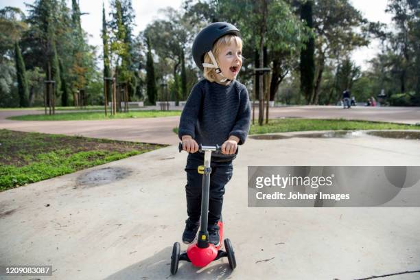 happy boy on scooter - kinder kickboard stock-fotos und bilder