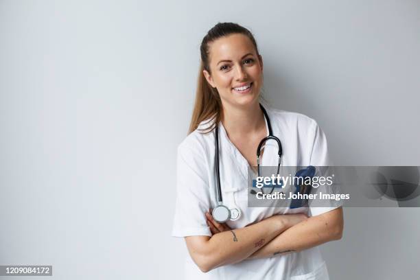 nurse looking at camera - female doctor portrait stockfoto's en -beelden