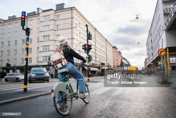 woman cycling in city - traffic light city stockfoto's en -beelden