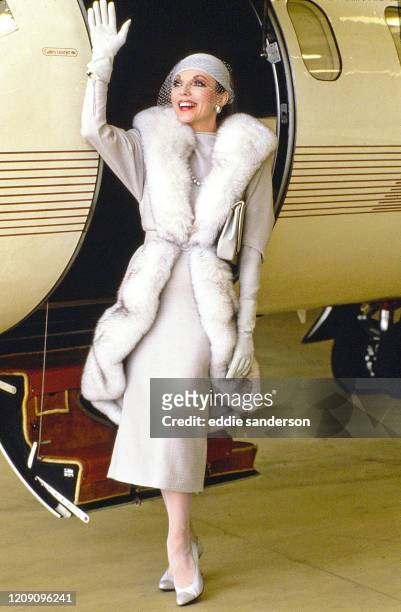 Actress Joan Collins poses outside of a Lear jet during the filming of the TV series Dynasty at Van Nuys airport, California in June 1986. .